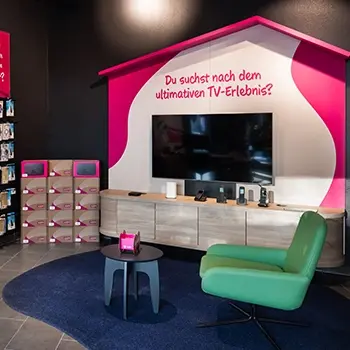 TV-Ausstellungsbereich mit großem Fernseher, Sofa und TV-Zubehör im Markt