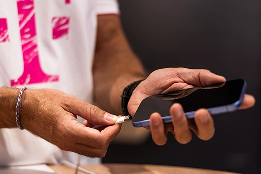 Hände halten Smartphone und stecken Ladekabel ein, Handy aufladen Nahaufnahme