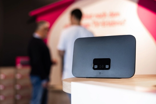 WLAN-Router auf Tisch, im Hintergrund unscharfe Personen im Telekom-Shop